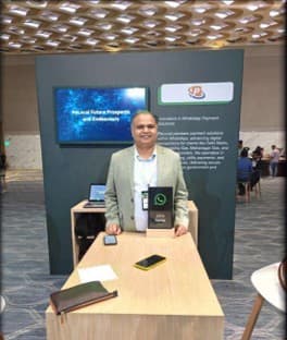 The award held at the Pelocal stand, beside a phone demonstrating a WhatsApp payment flow.