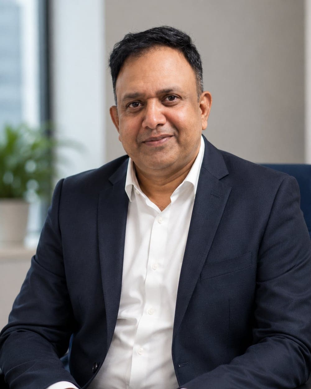 Rahul Kumar, Vice President of Sales & Marketing at Pelocal, seated in a dark suit and open-collar shirt in the office.